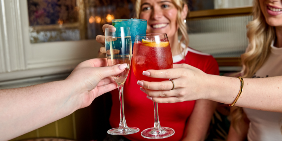 3 PEOPLE CHEERSING COCKTAILS