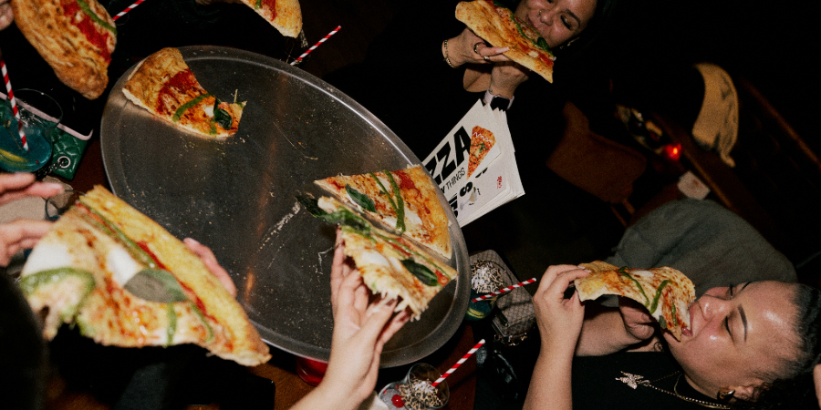 People enjoying Rita's pizza slices