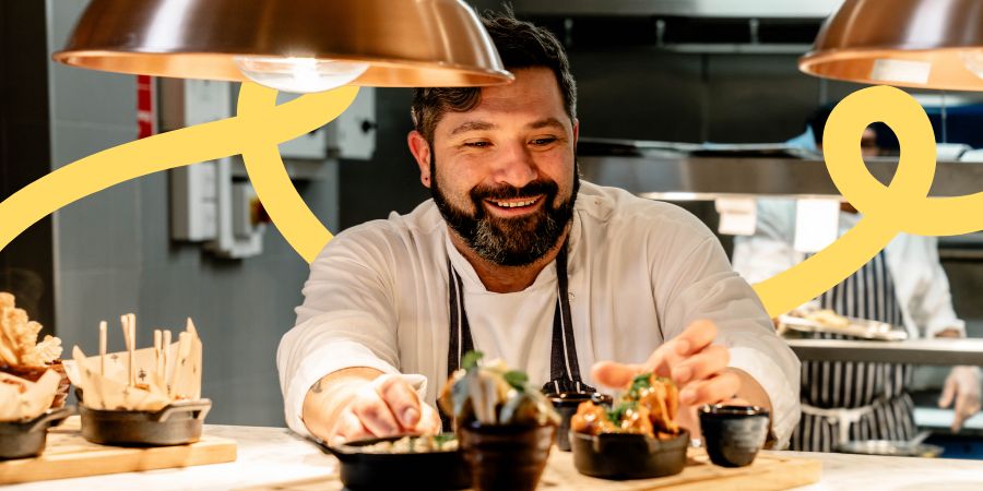 Man dressed in chef uniform plating up food