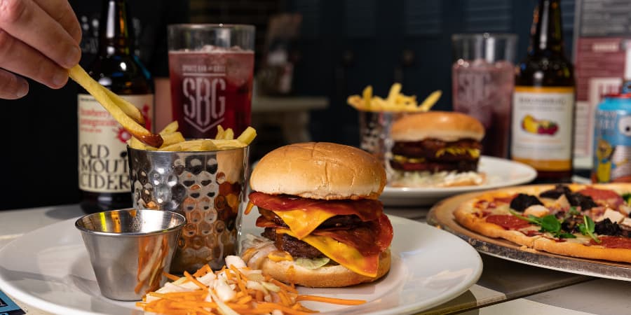 Burger, fries and pizza with drinks