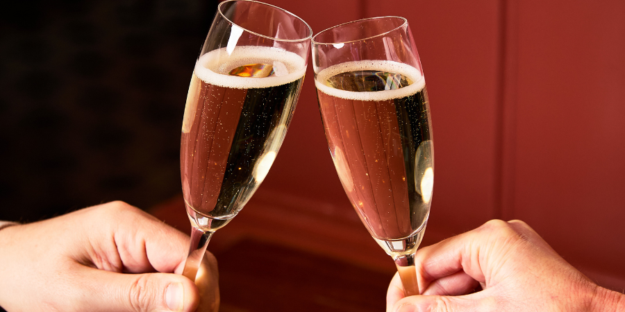 2 people cheersing champagne