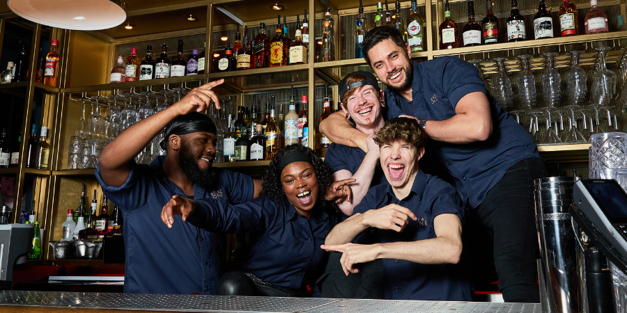 Group of Be A One Bartenders smiling at the camera.