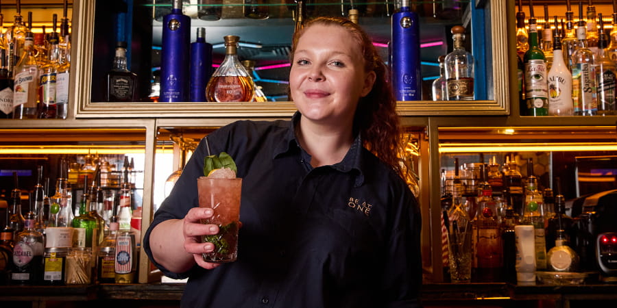 Runner Up, Kira posing with their cocktail.