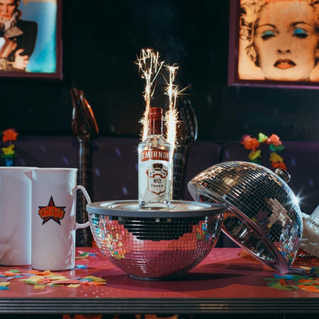 Vodka bottle package served in a disco ball with sparklers