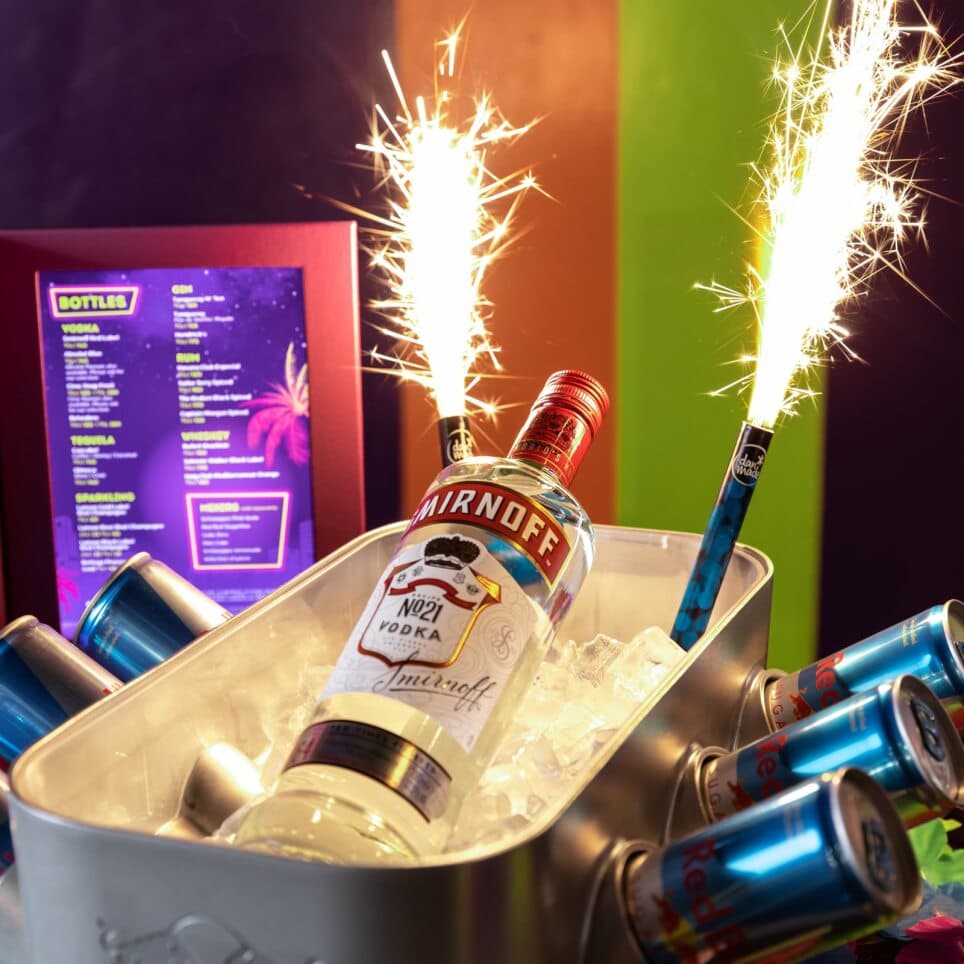 Bottle of vodka with energy drink cans and sparklers