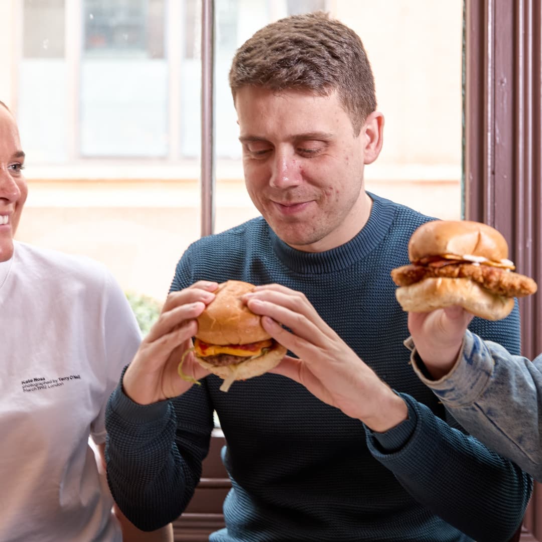 Friends enjoying beef burgers and chicken burgers Friends enjoying beef burgers and chicken burgers