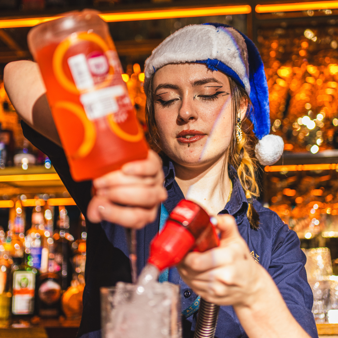 Blue santa pouring a cocktail at Be At One