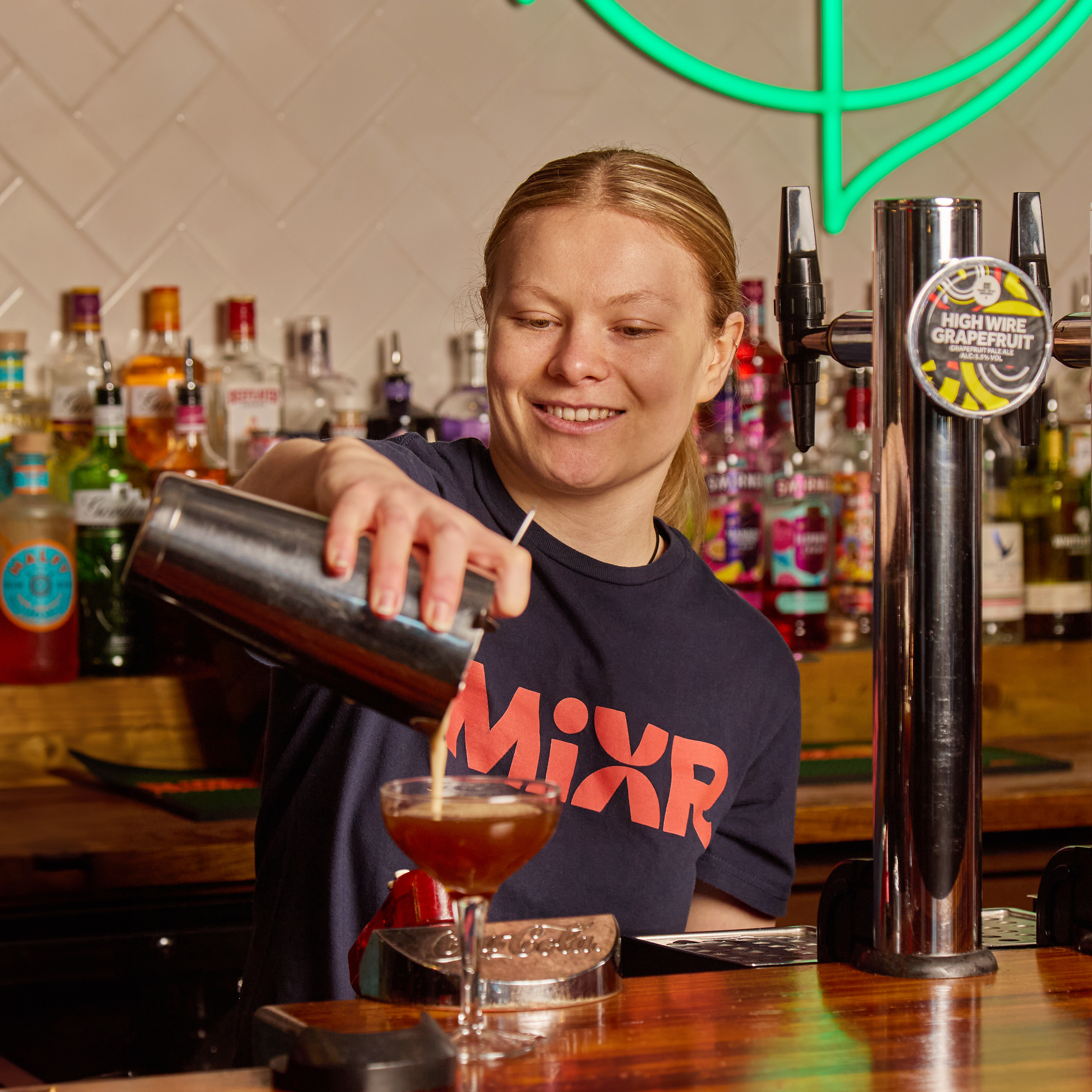 Team Member behind the bar smiling at the camera.