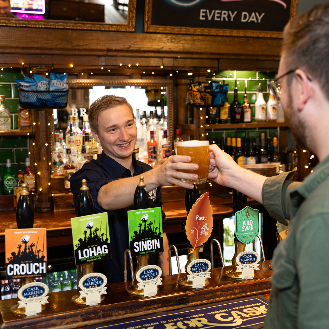 Team Leader handing a guest a pint over the bar