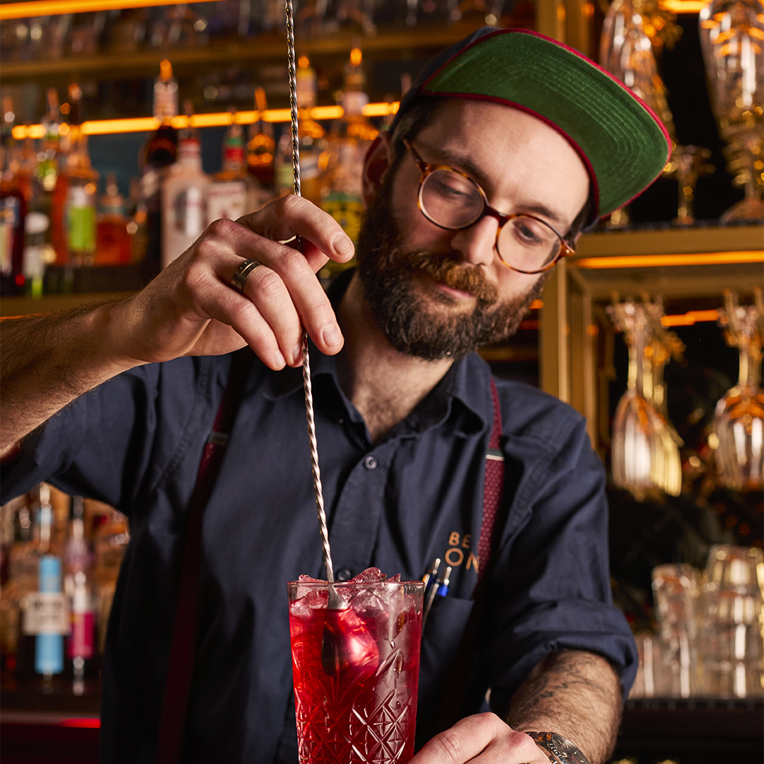 Deputy Manager stirring a cocktail behind the bar