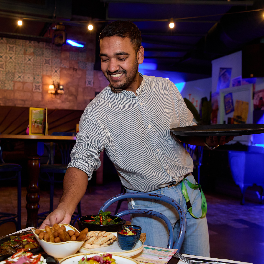 Deputy Manager serving a table with plates