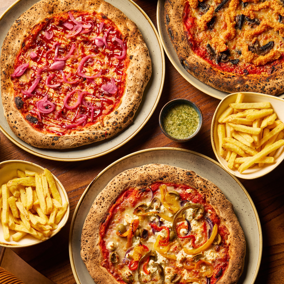 3 pizzas and sides on table