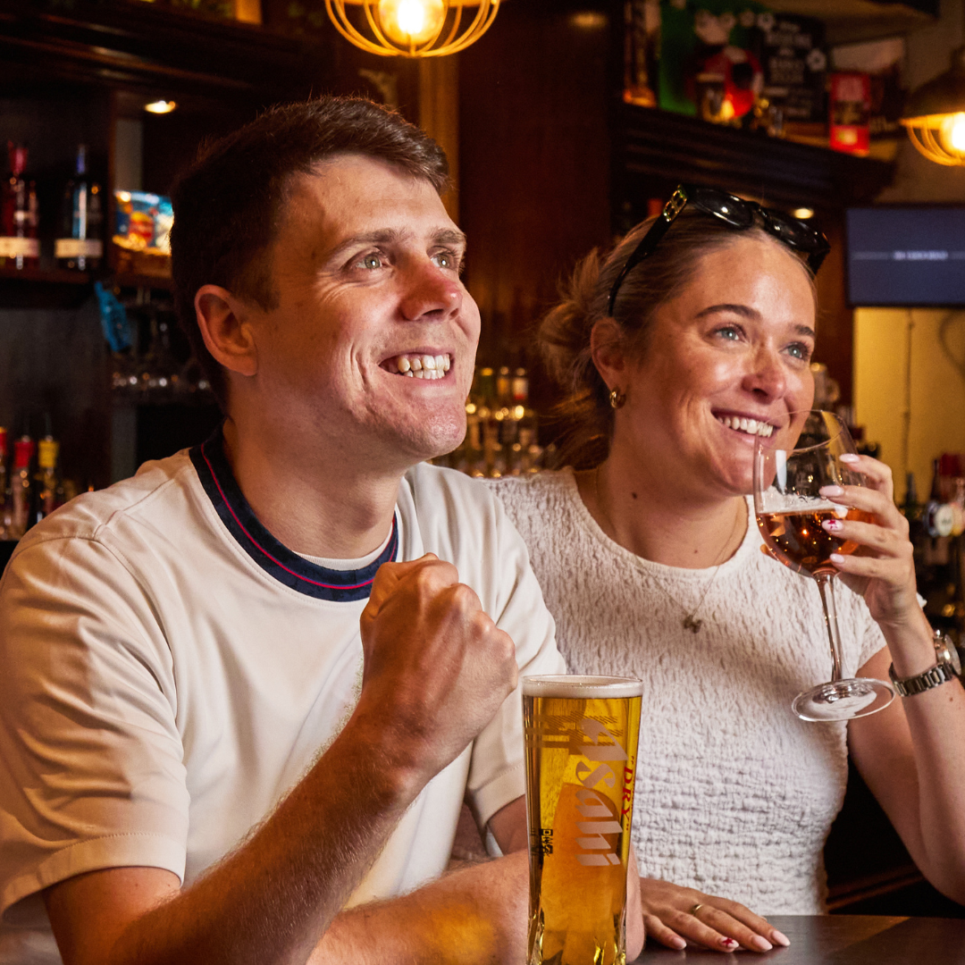 2 PEOPLE WATCHING WIMBLEDON WITH DRINKS
