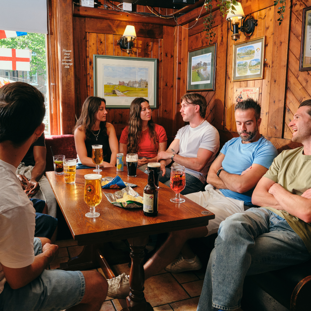 Group of people gathered around a table for world cup games