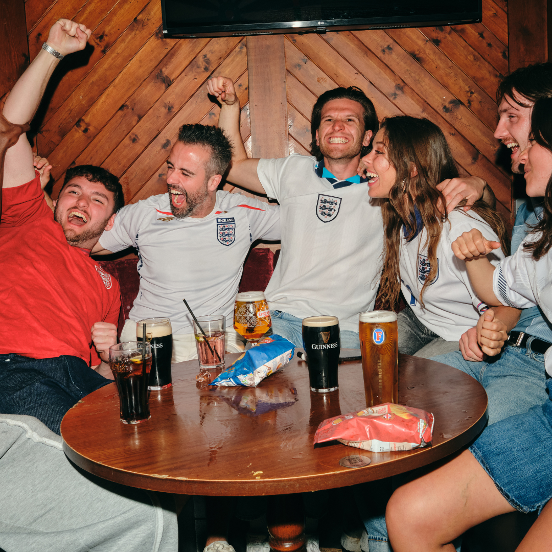 Group of people gathered around a table for world cup games