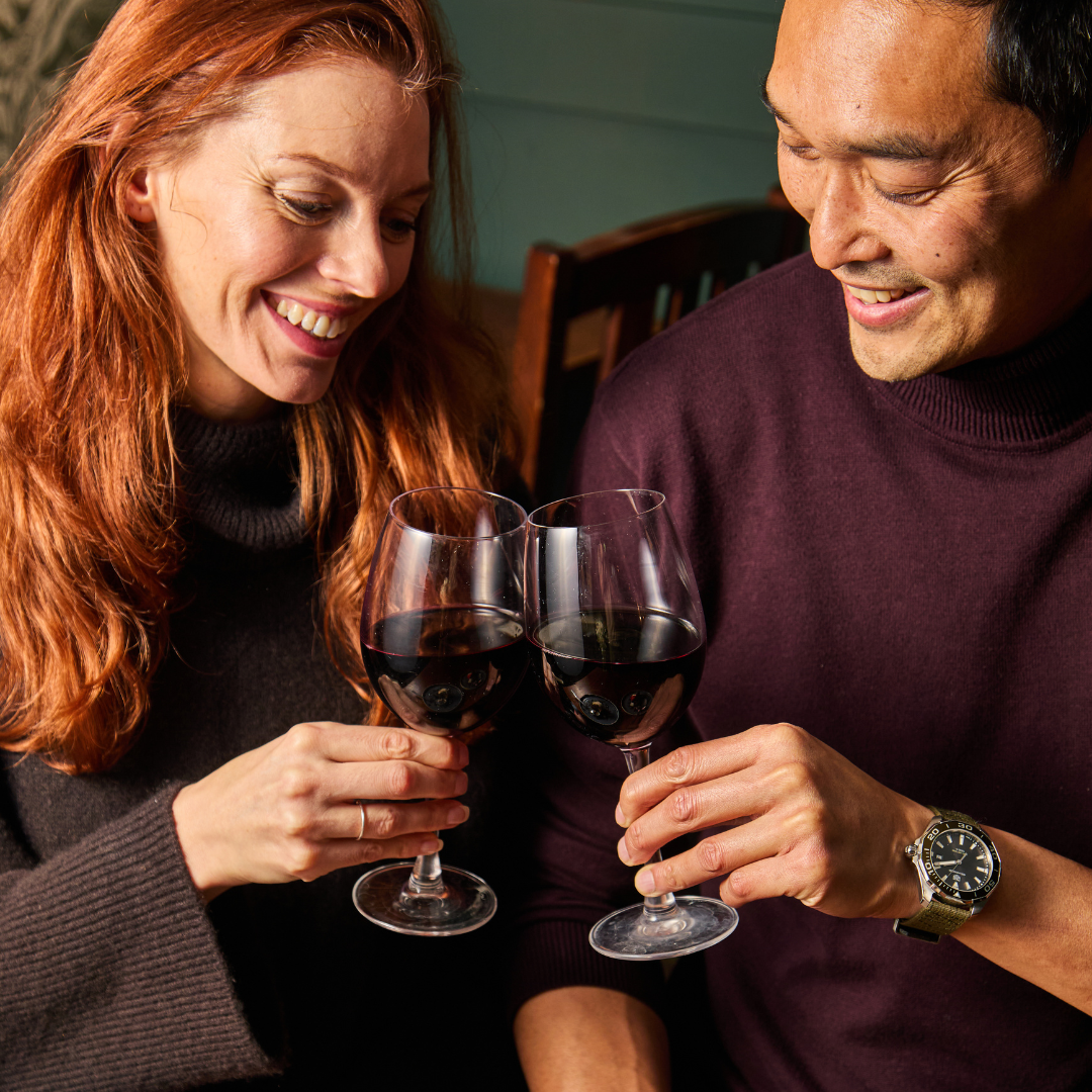 A couple with glasses of red wine