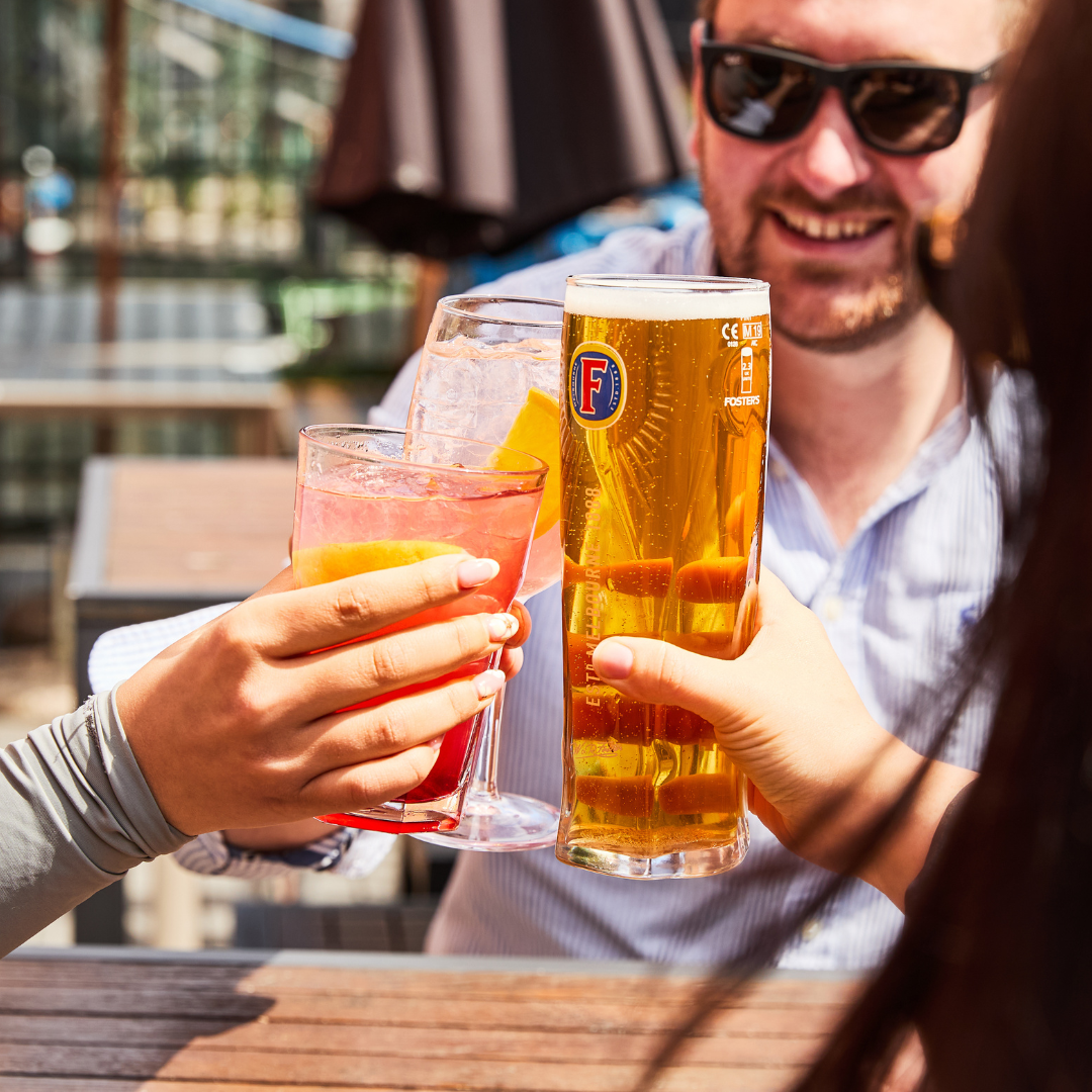 3 people with drinks in beer garden