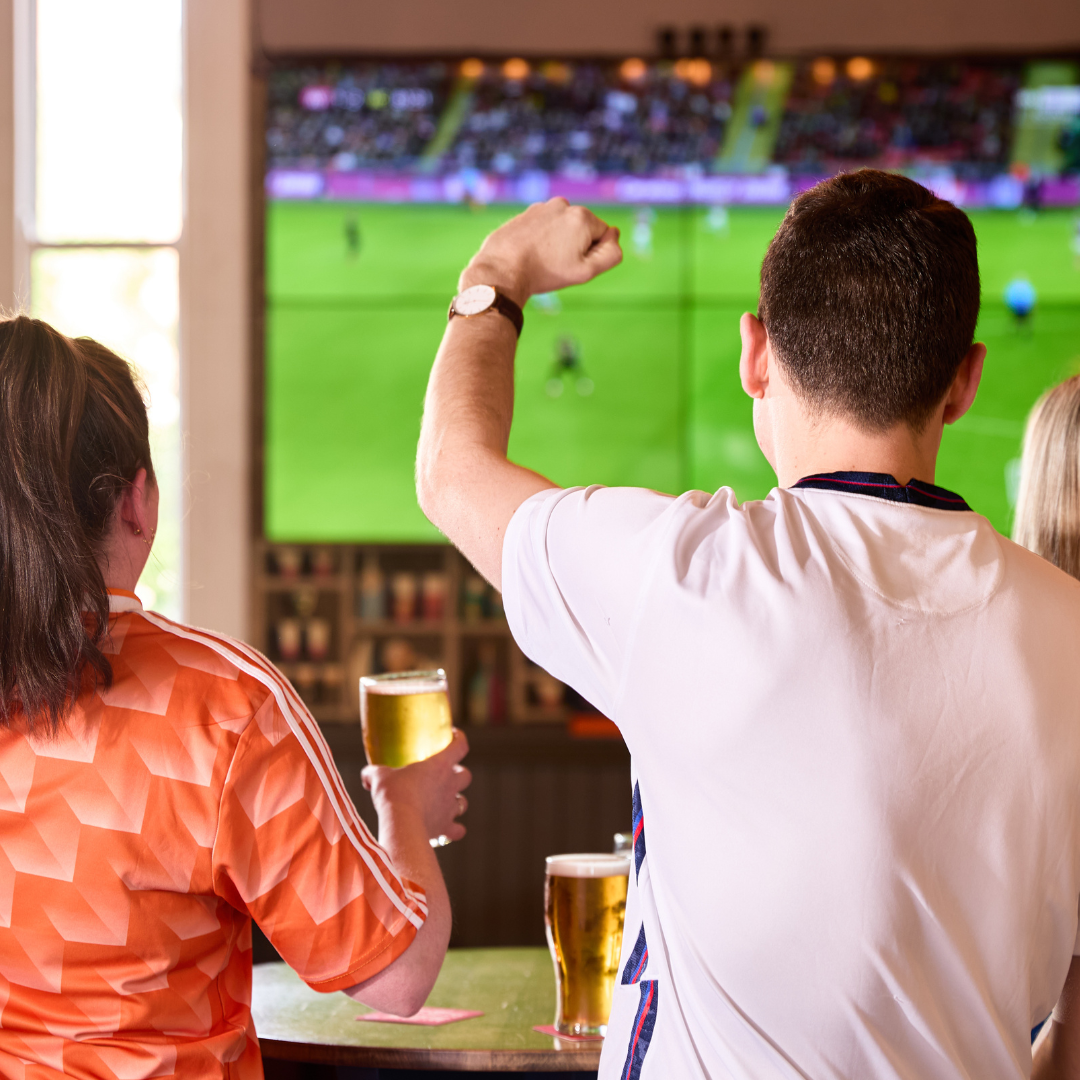 2 people in pub watching football