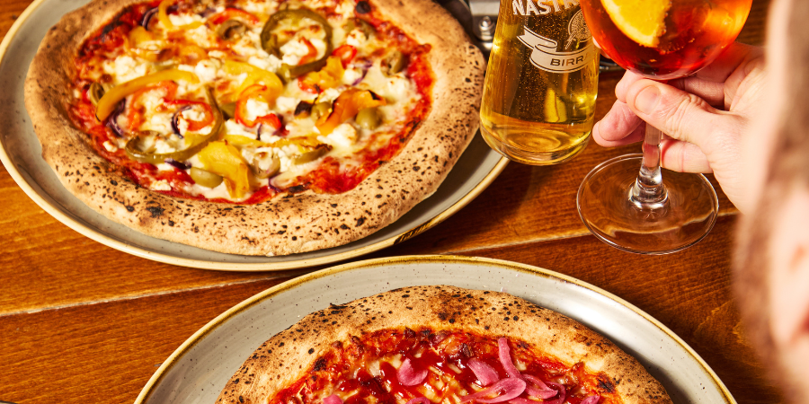 2 pizzas and fries on table