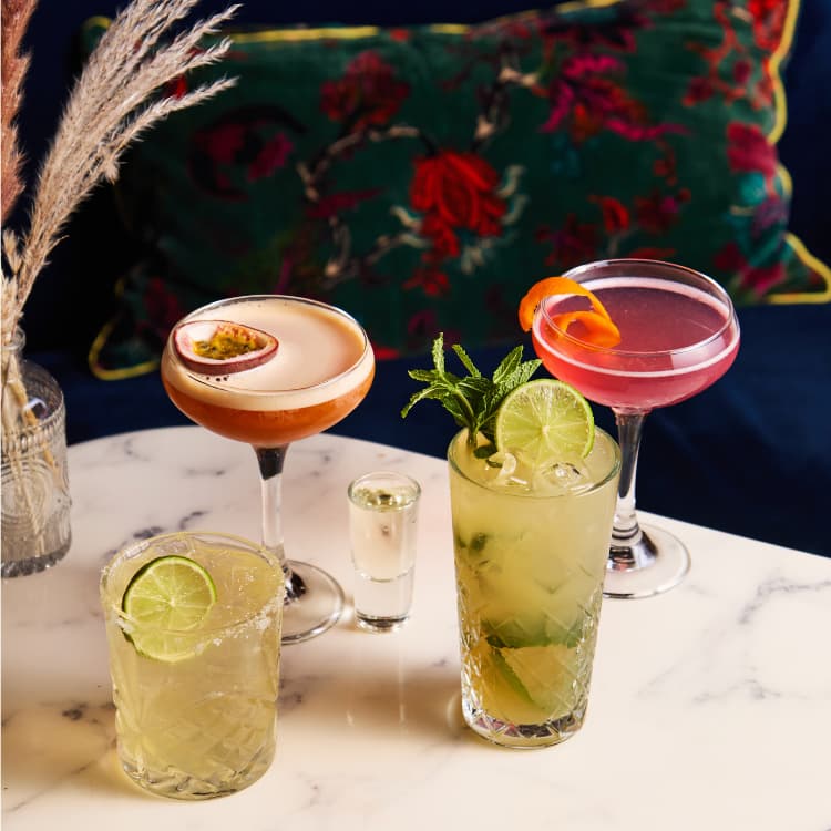 Selection of four cocktails on a marble table