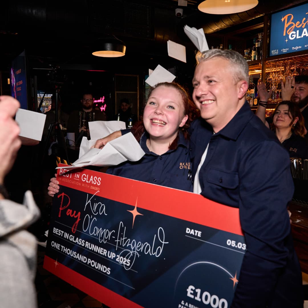 Be At One Bartender and Area Manager holding a large cheque.