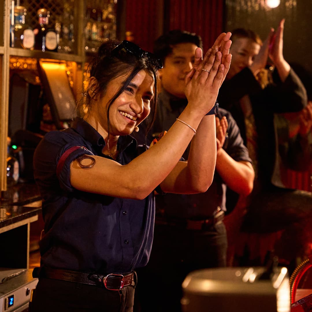 Contestants applauding behind the bar.