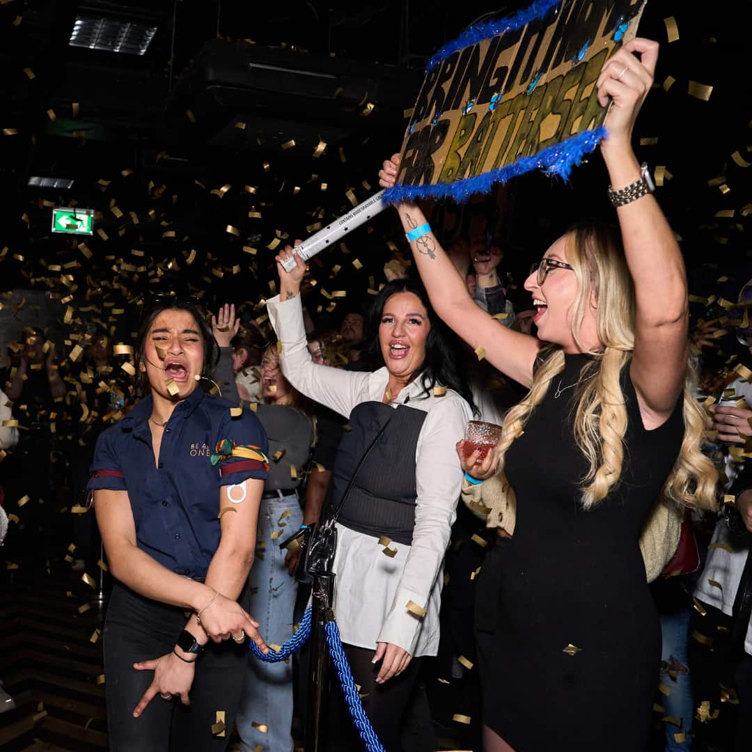 Bartender in front of the crowd with signs. 