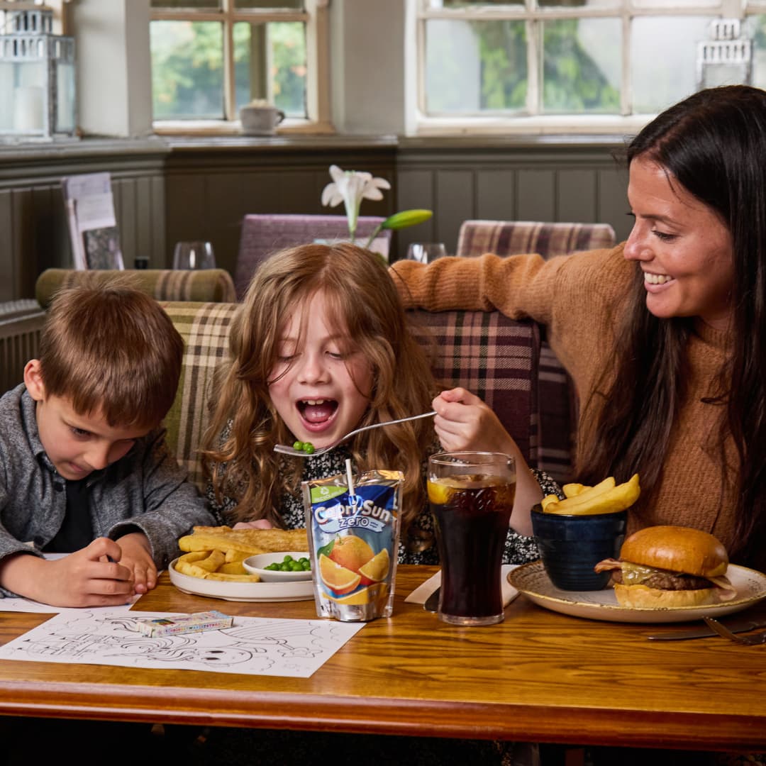 two children and their parent eating in a pub