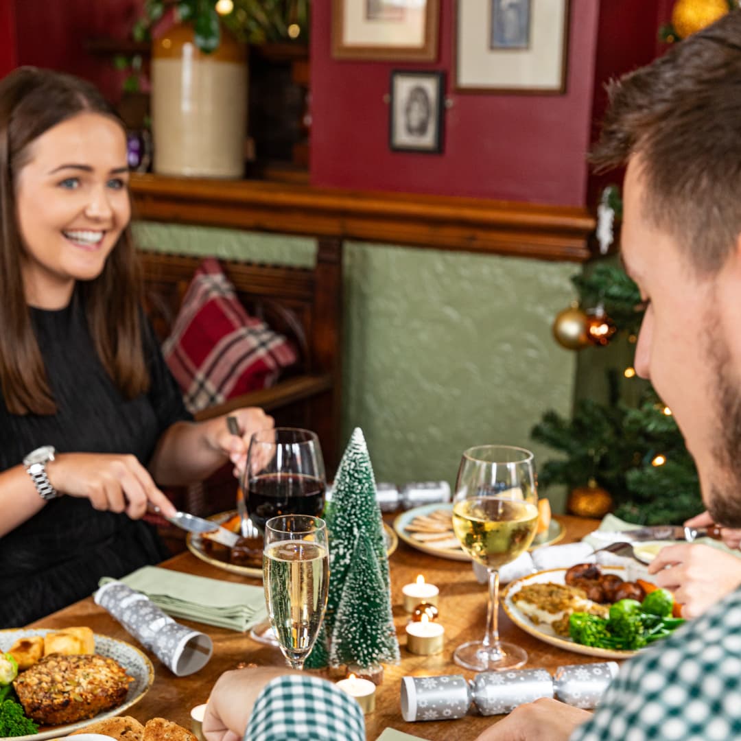 People Sitting at a Table in a Pub Eating Christmas Dinner