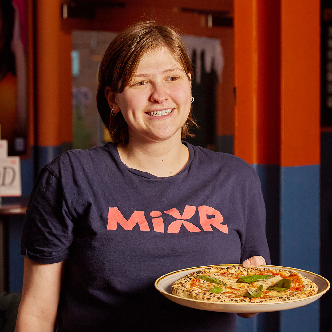 Team member carrying a pizza.