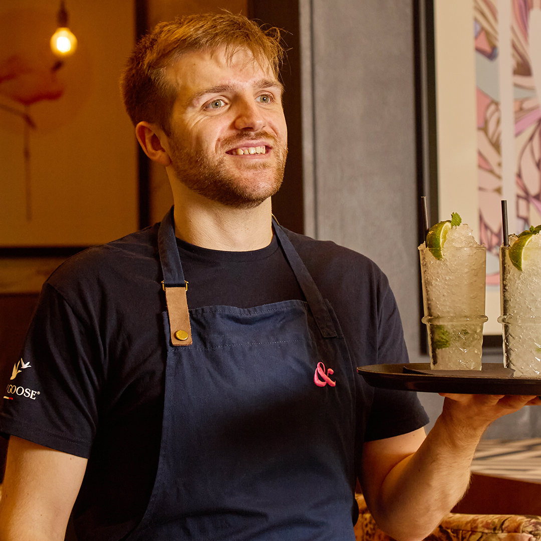 S&L team member carrying a tray of cocktails