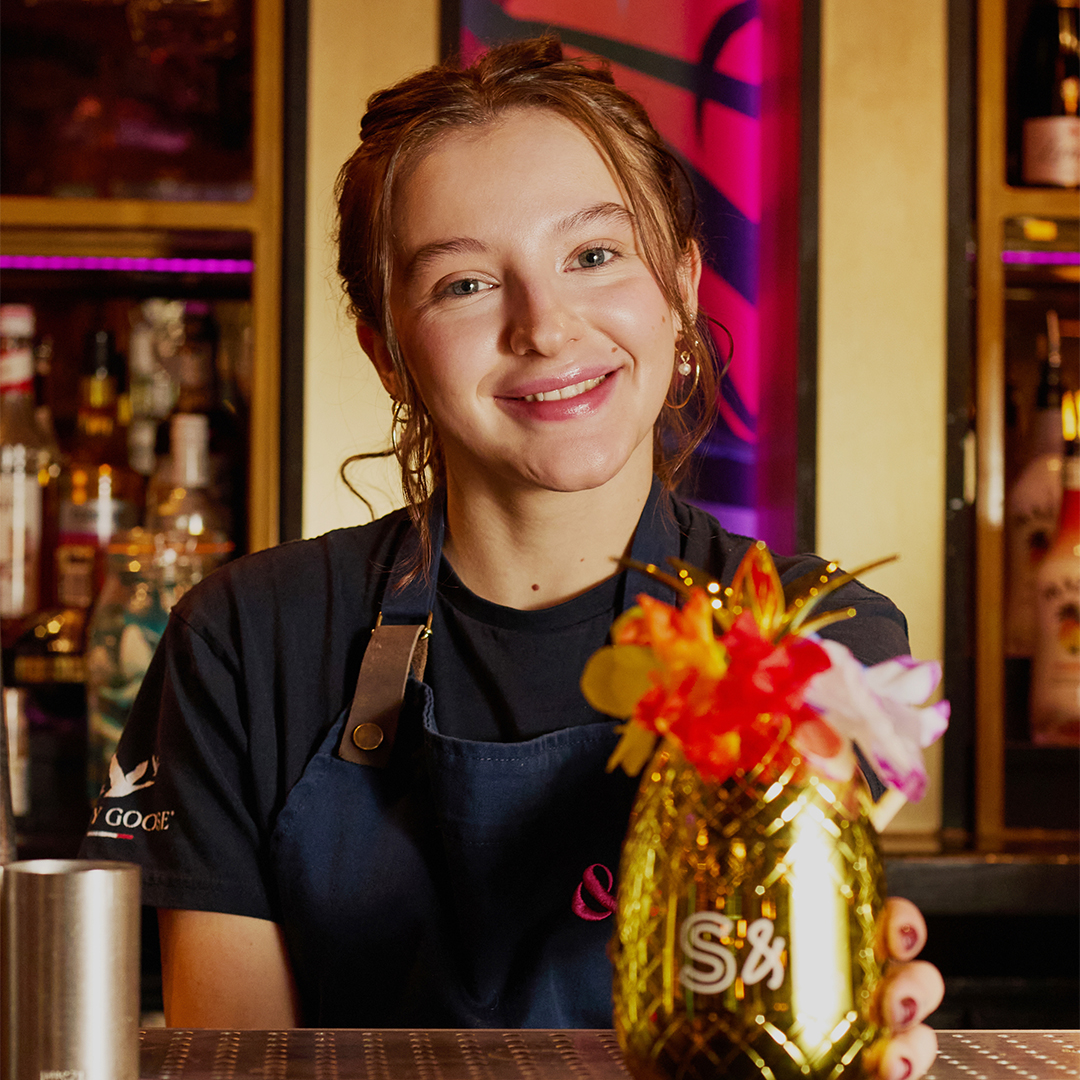S&L team member with a pina colada cocktail