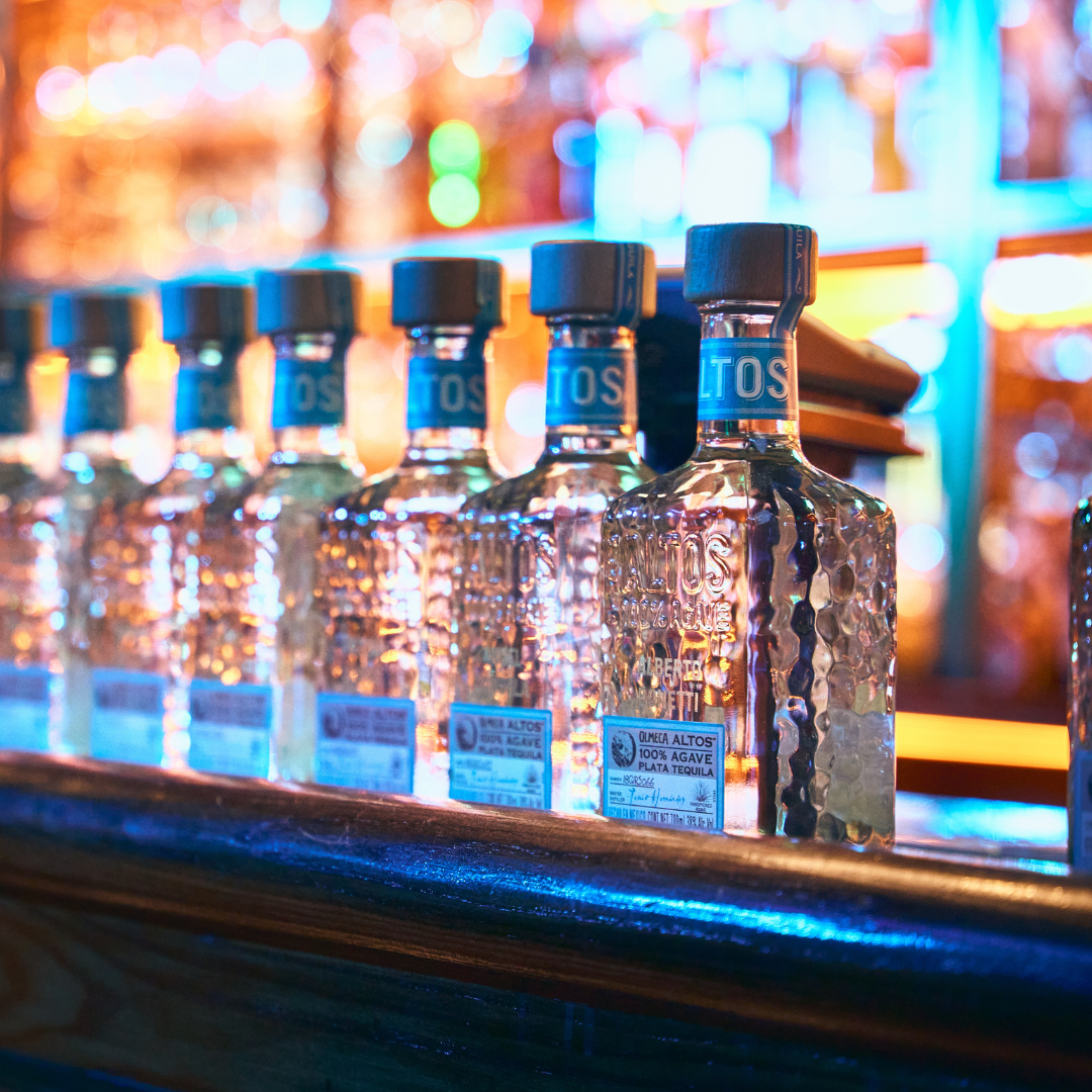 Bottles of Altos tequila lined up on the bar