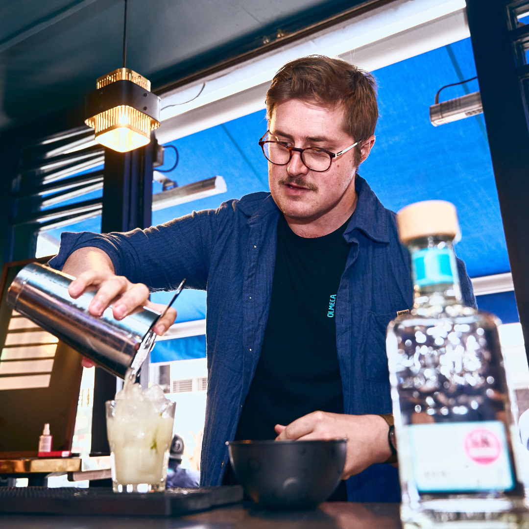 Bartender pouring cocktail into a glass