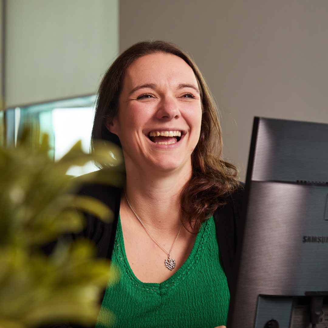 HR team member smiling away from camera in front of computer