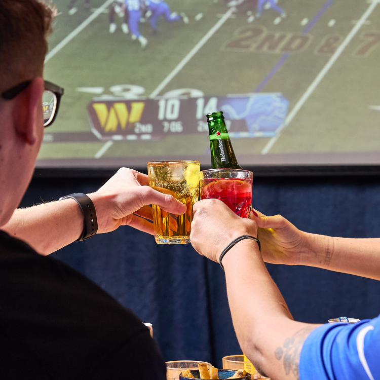 People watching Super Bowl & Cheersing drinks