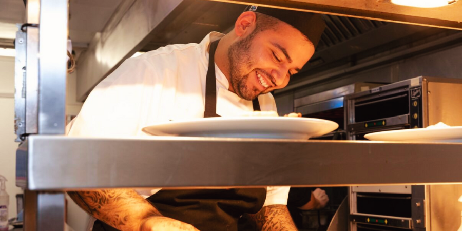 Chef smiling from behind the pass.