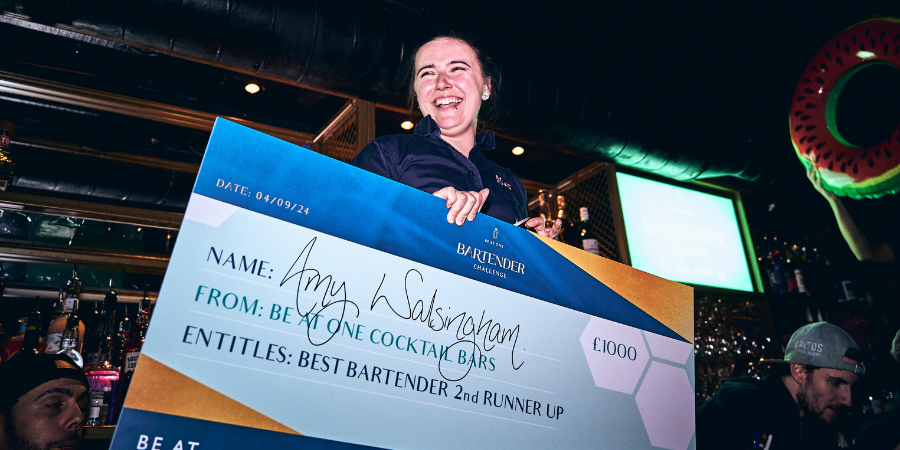 Amy, second runner up celebrating with friends while holding a cheque