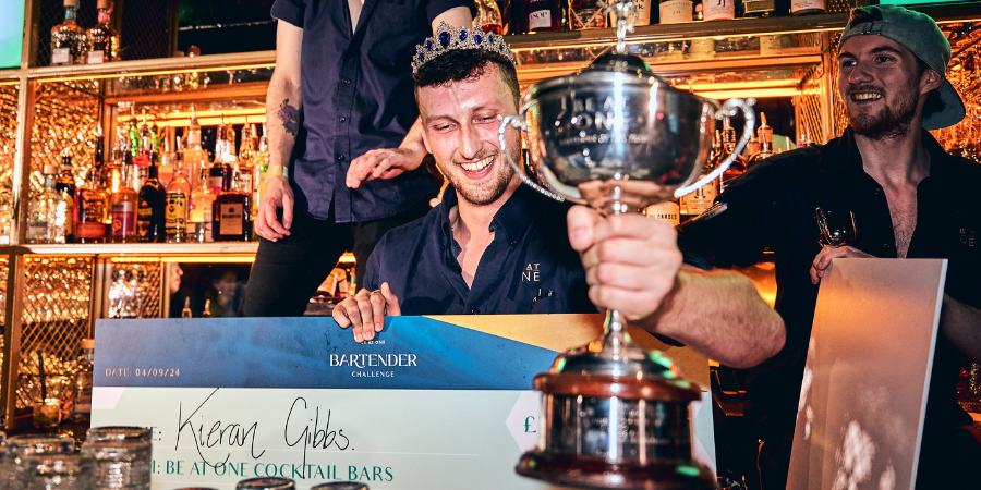 Best Bartender Winner Kieran holding a cheque and trophy