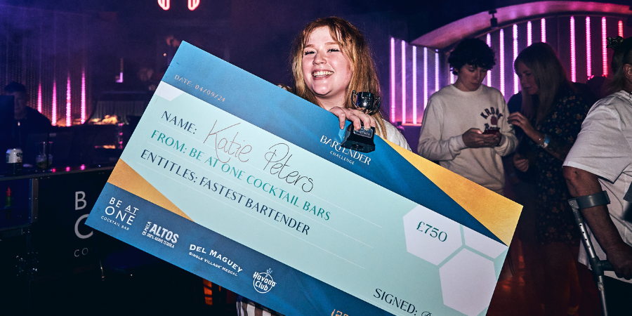 Katie, winner of Fastest Bartender holding her winning cheque