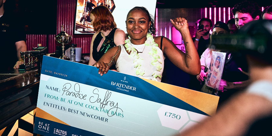 Paradise celebrating her Best Newcomer win and holding her cheque