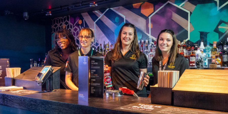 Nightclub team members behind a bar.